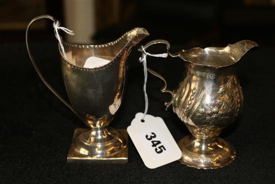 George II embossed silver pedestal cream jug, London 1759, D & R Hennell & a George III plain silver pedestal cream jug